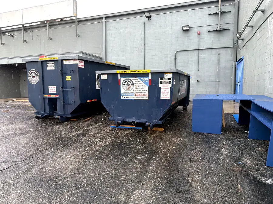 Two roll-off cans staged at a commercial site